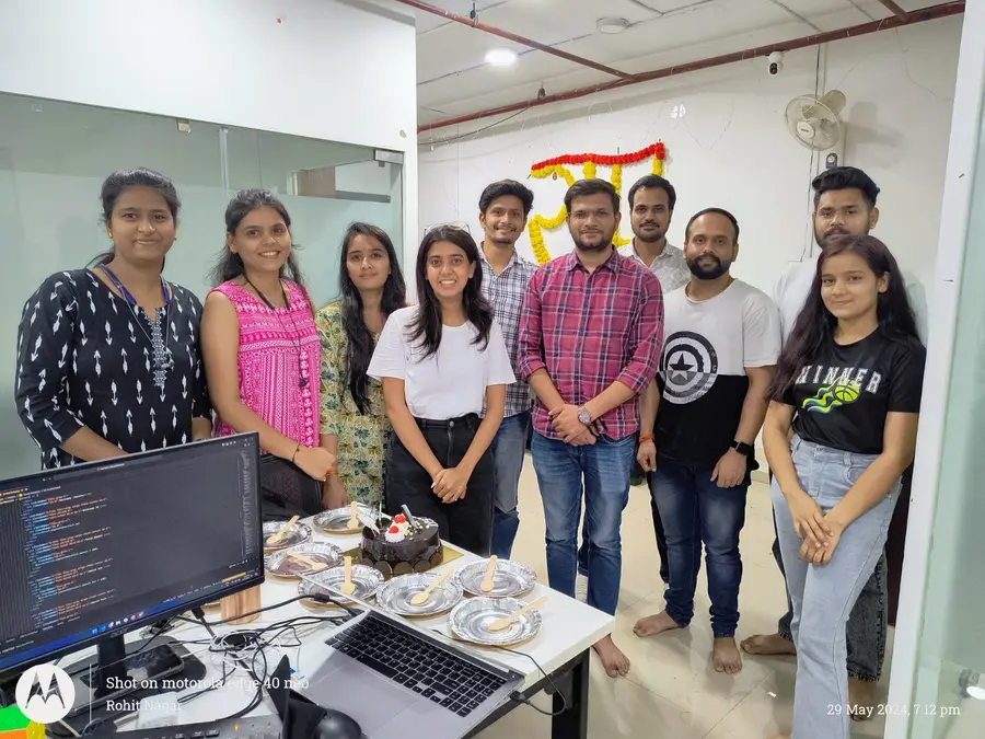 The team celebrating around a cake at their desks in the AppWizards office
