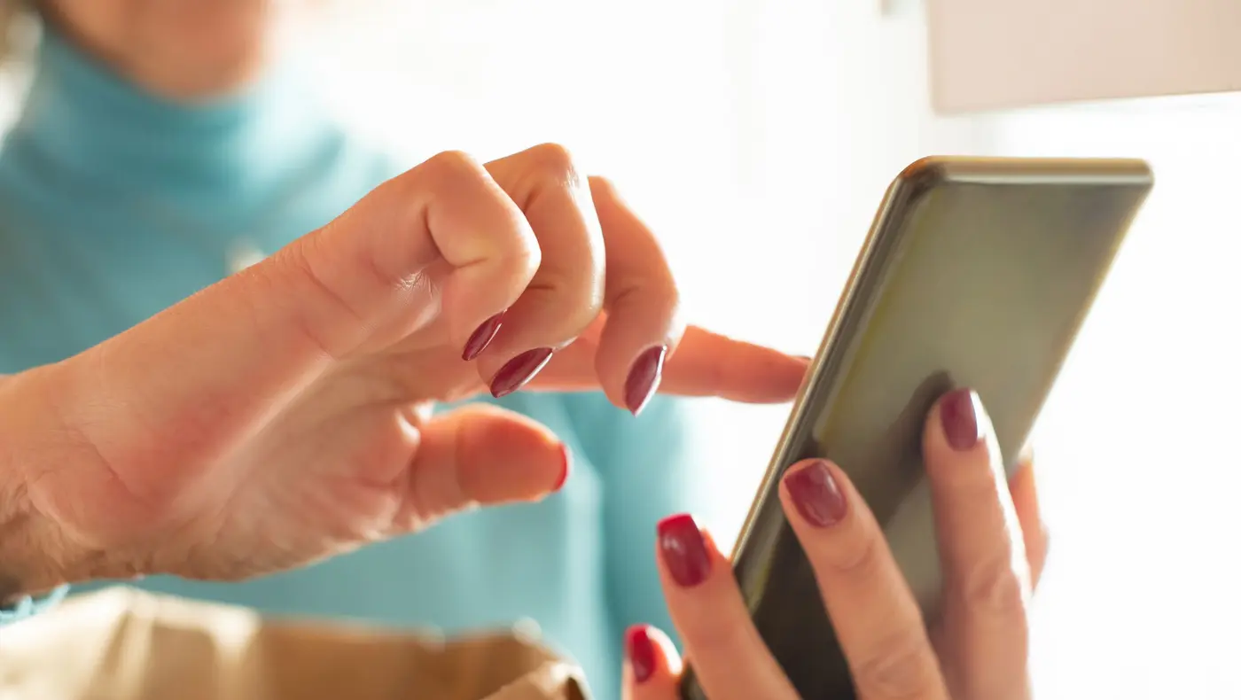 Close up of a hand tapping the screen of a smartphone