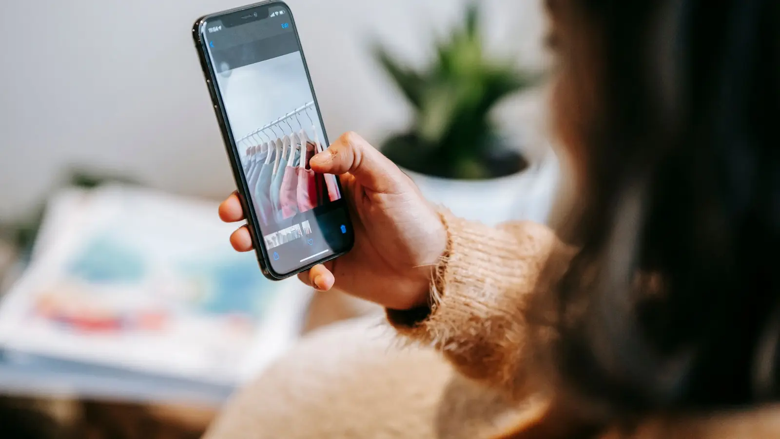 A person browsing a rail of clothes on a shopping screen on their smartphone