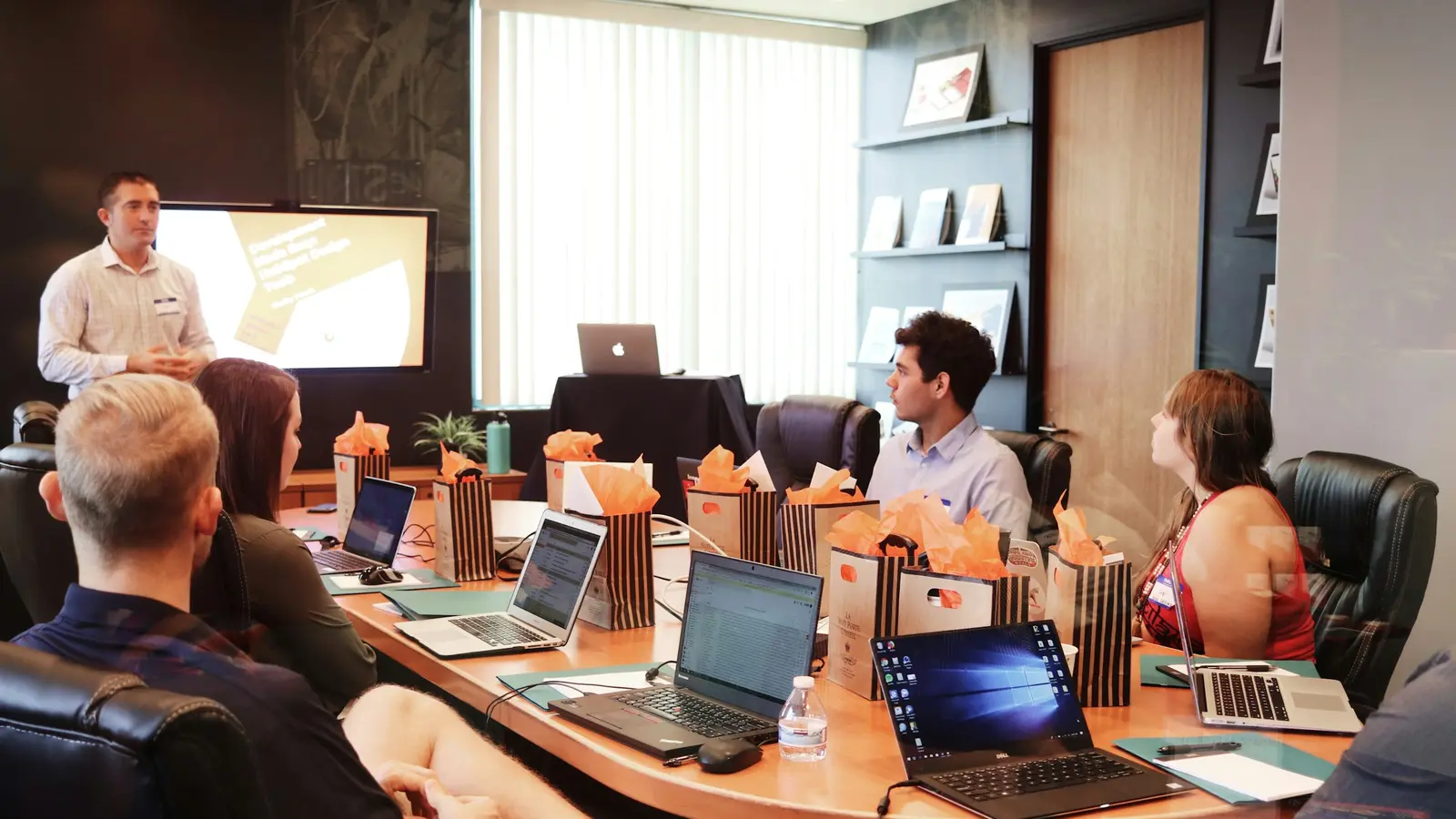 A team meeting in a conference room, one person presenting at a screen.